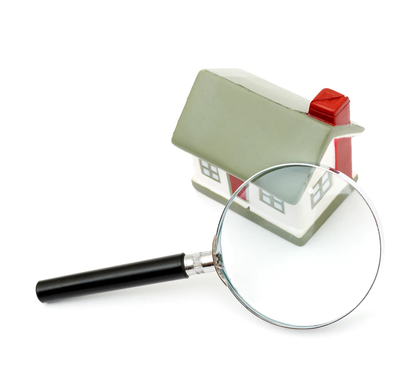 A small home behind a magnifying glass on a white background.