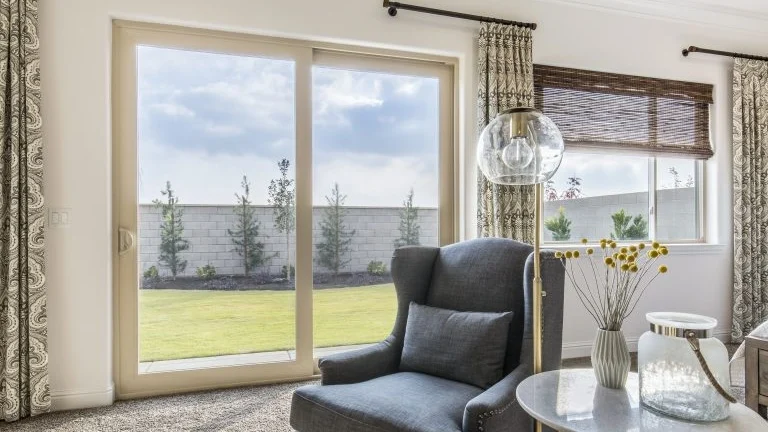 A living room with a sliding patio door and a window to the right