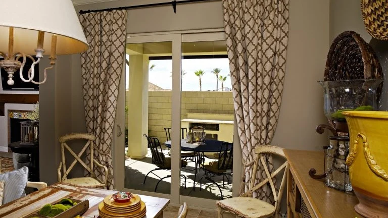An indoor dining area next to a patio door that leads to an outdoor dining area