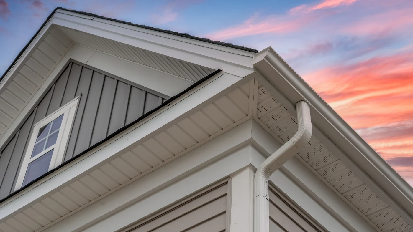 A home with tan siding and white trim, soffits, and gutters