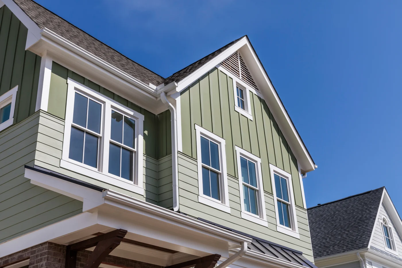 Green vertical siding with white trim.