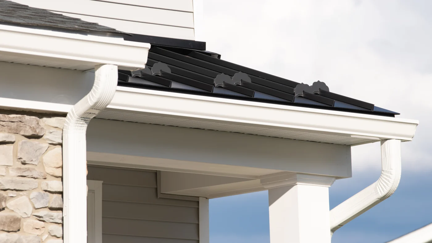 White seamless gutters installed on a home with stone veneer