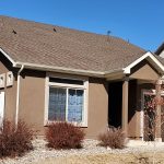 The second story of a home beige stucco and a tile roof