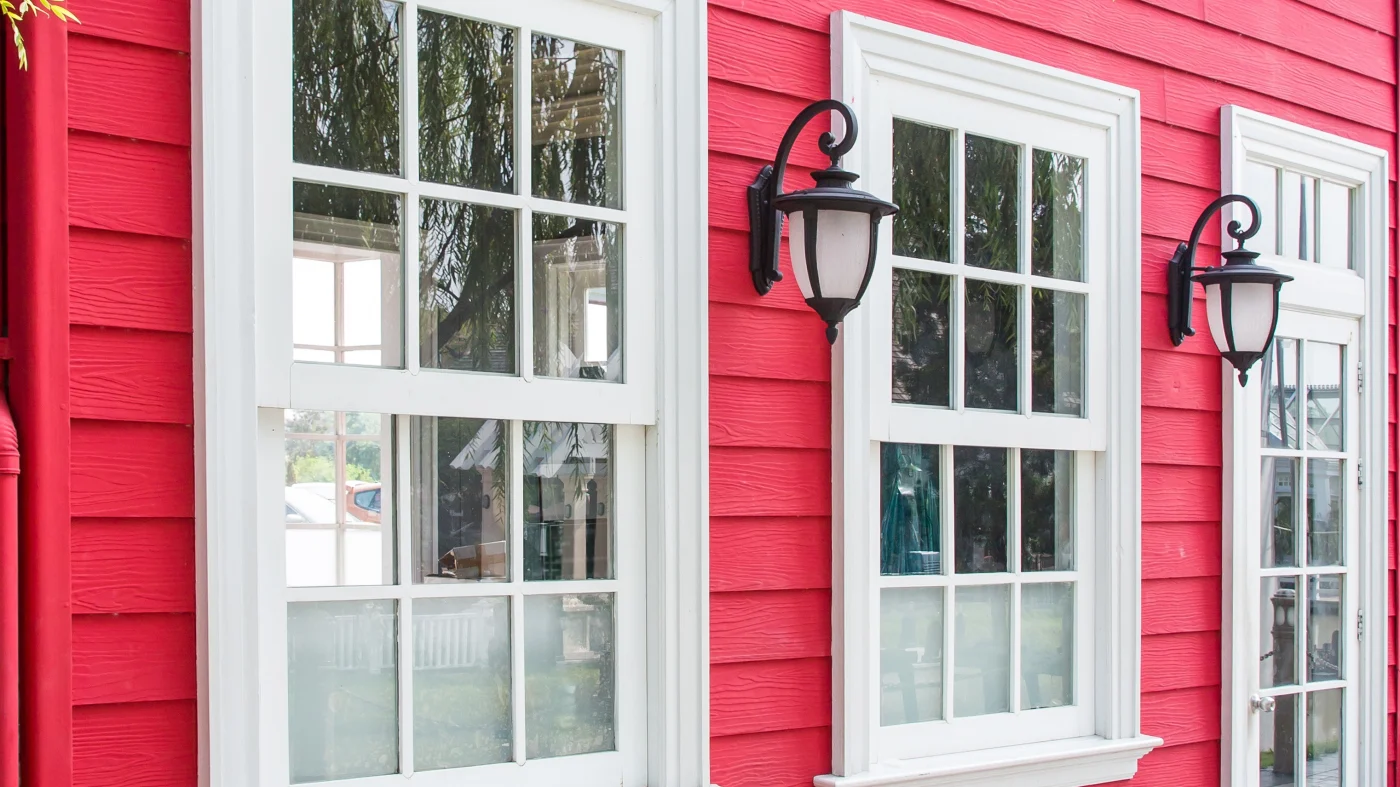 The exterior of a home with vibrant magenta siding and white windows