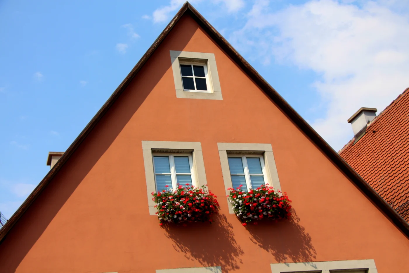 A low-angle view of a home with smoothly finished orange stucco.