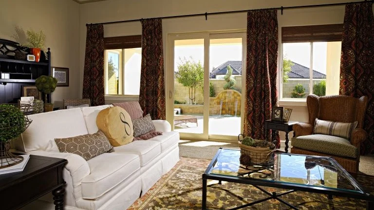 A living room with a patio door with windows on either side
