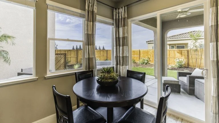 A dining area with a sliding patio door leading to a patio seating area