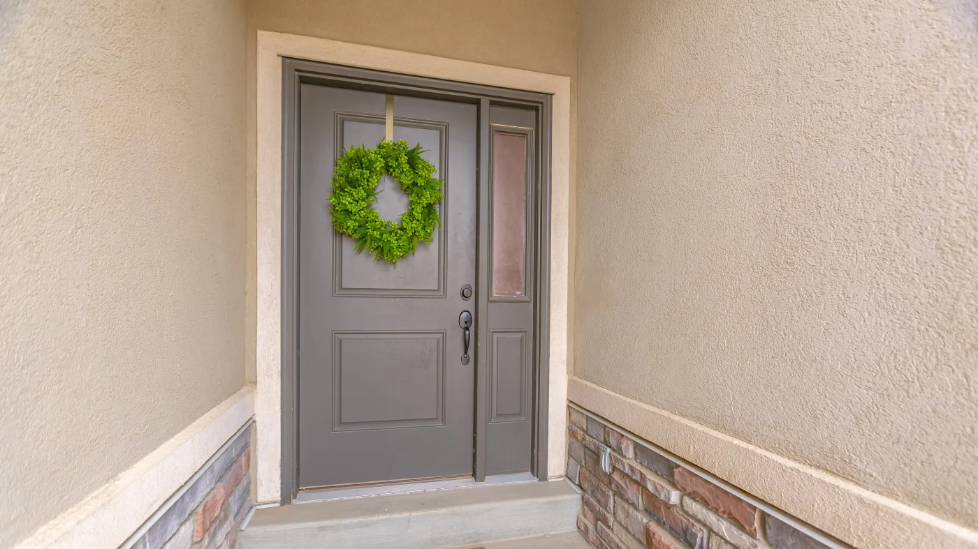 An entryway with a gray door and white trim