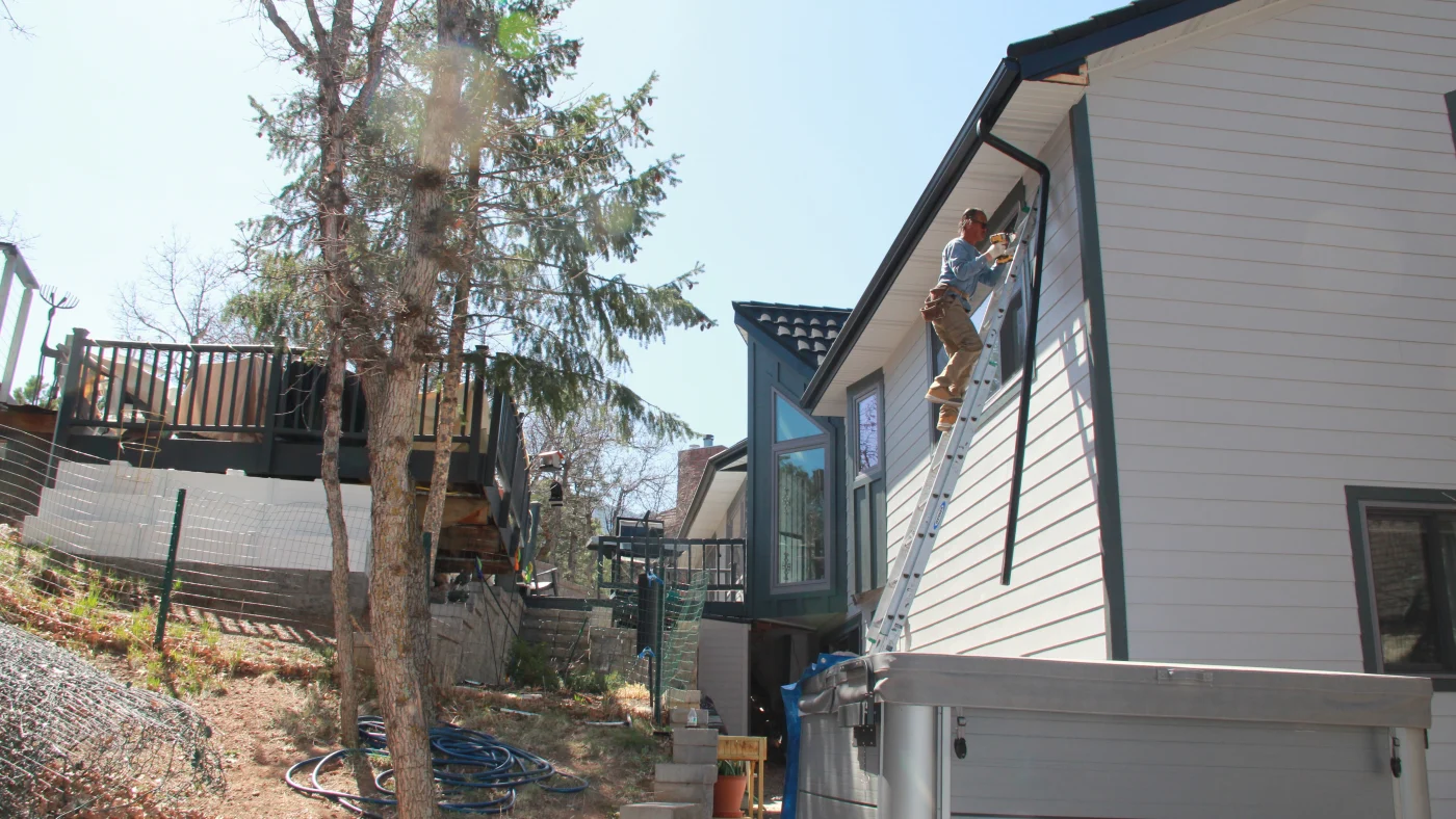 A Peakview contractor installing white siding on a home