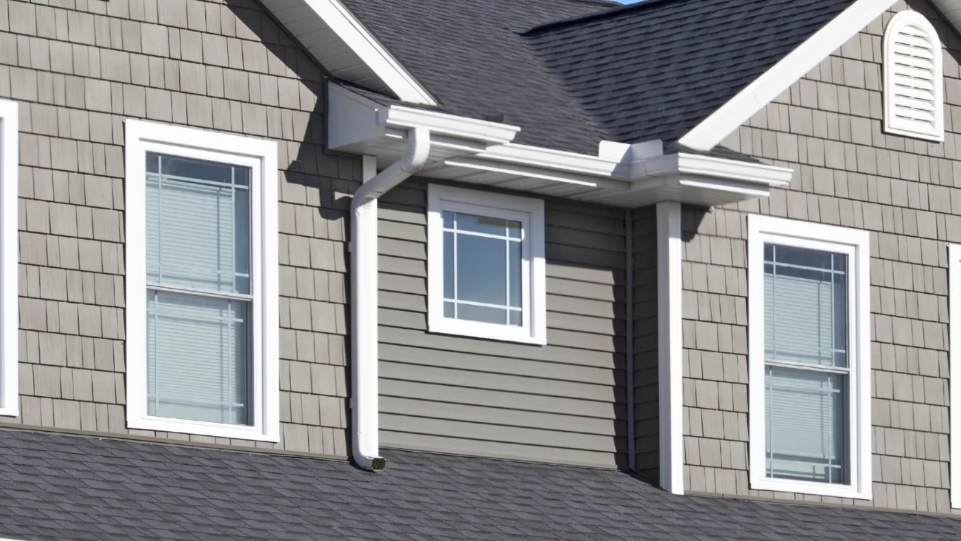 White seamless gutters installed on a home with gray siding