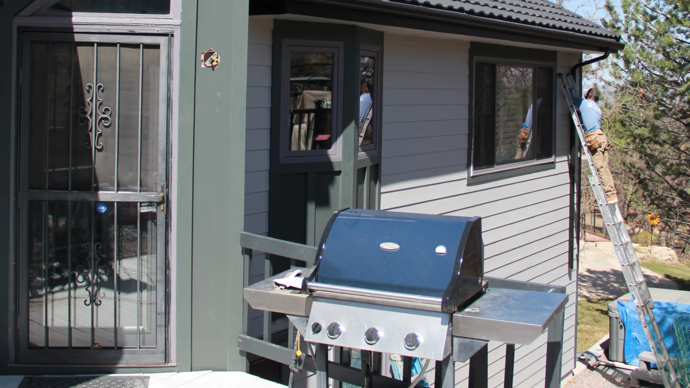 A Peakview contractor installing white siding on a home