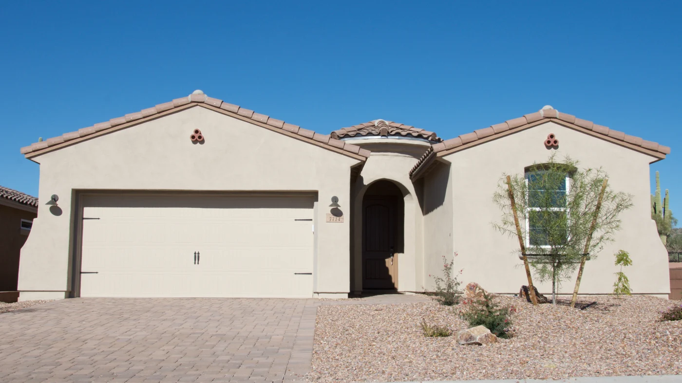 A home with tan stucco and a tile roof