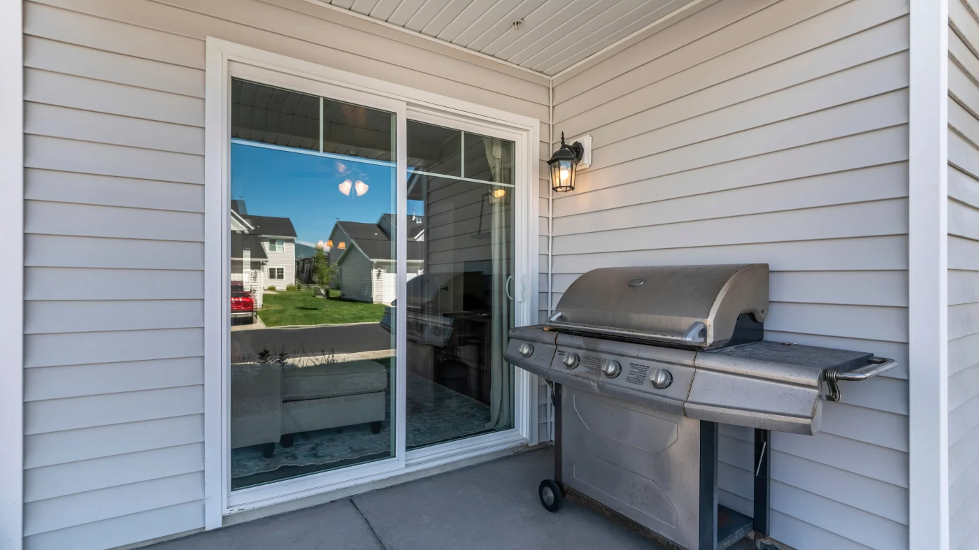 A sliding patio door installed on a home with vinyl siding.