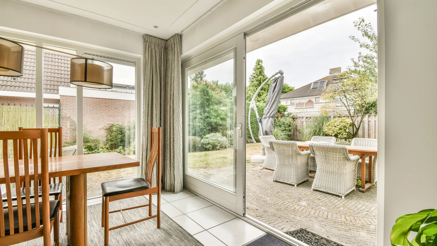 A dining area with an open patio door overlooking the patio seating area