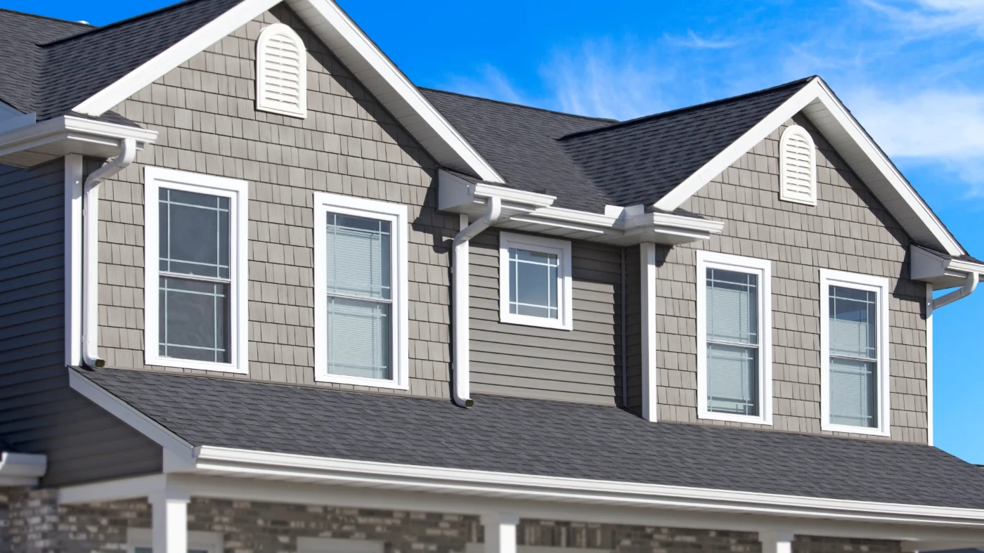 White seamless gutters installed on a home with gray siding