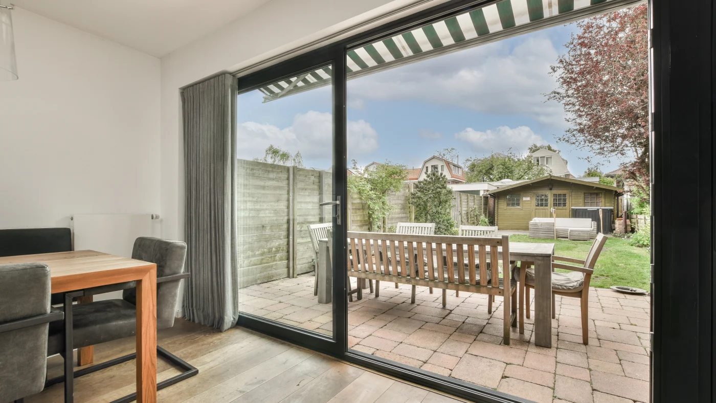 A dining area with an open patio door overlooking the patio seating area