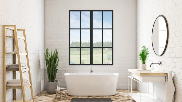 A bathroom with a black window over the standalone tub