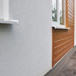 A home with gray stucco and brown wood siding