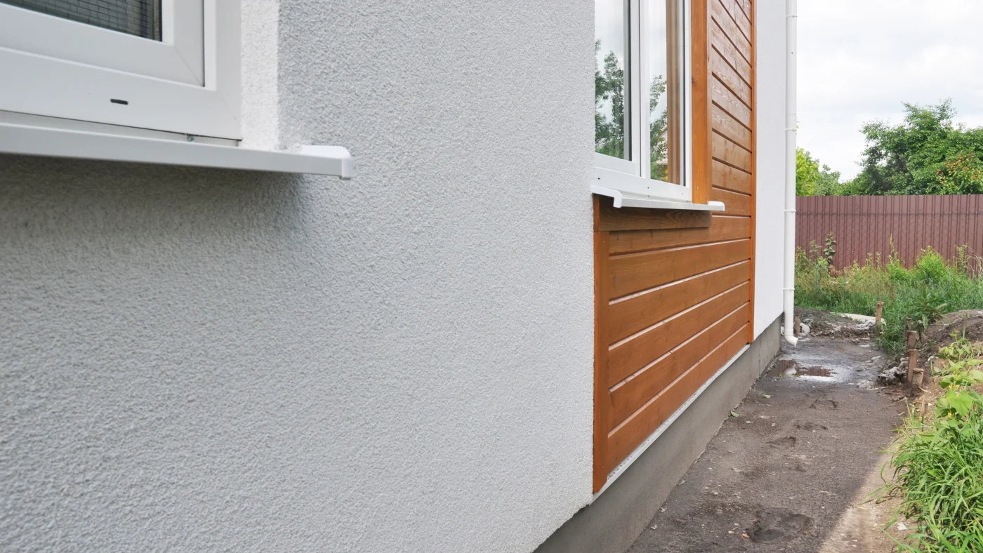 A home with gray stucco and brown wood siding