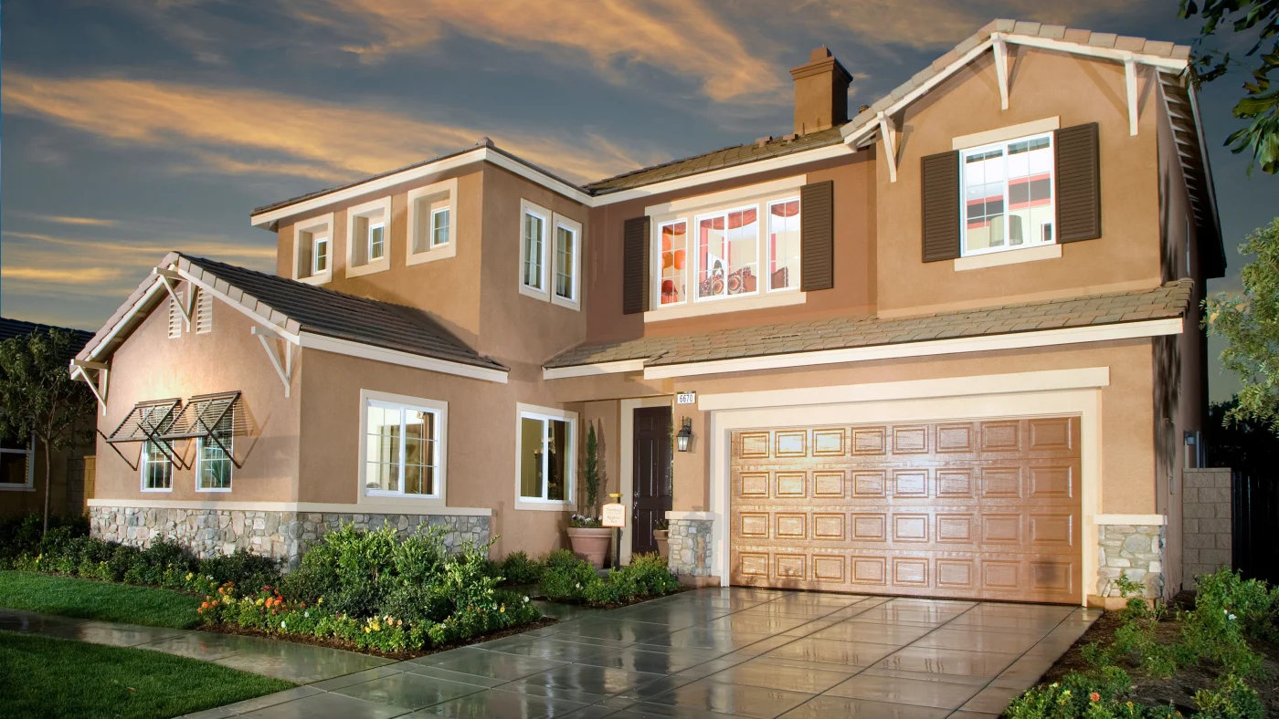 A home with tan stucco and white trim at night