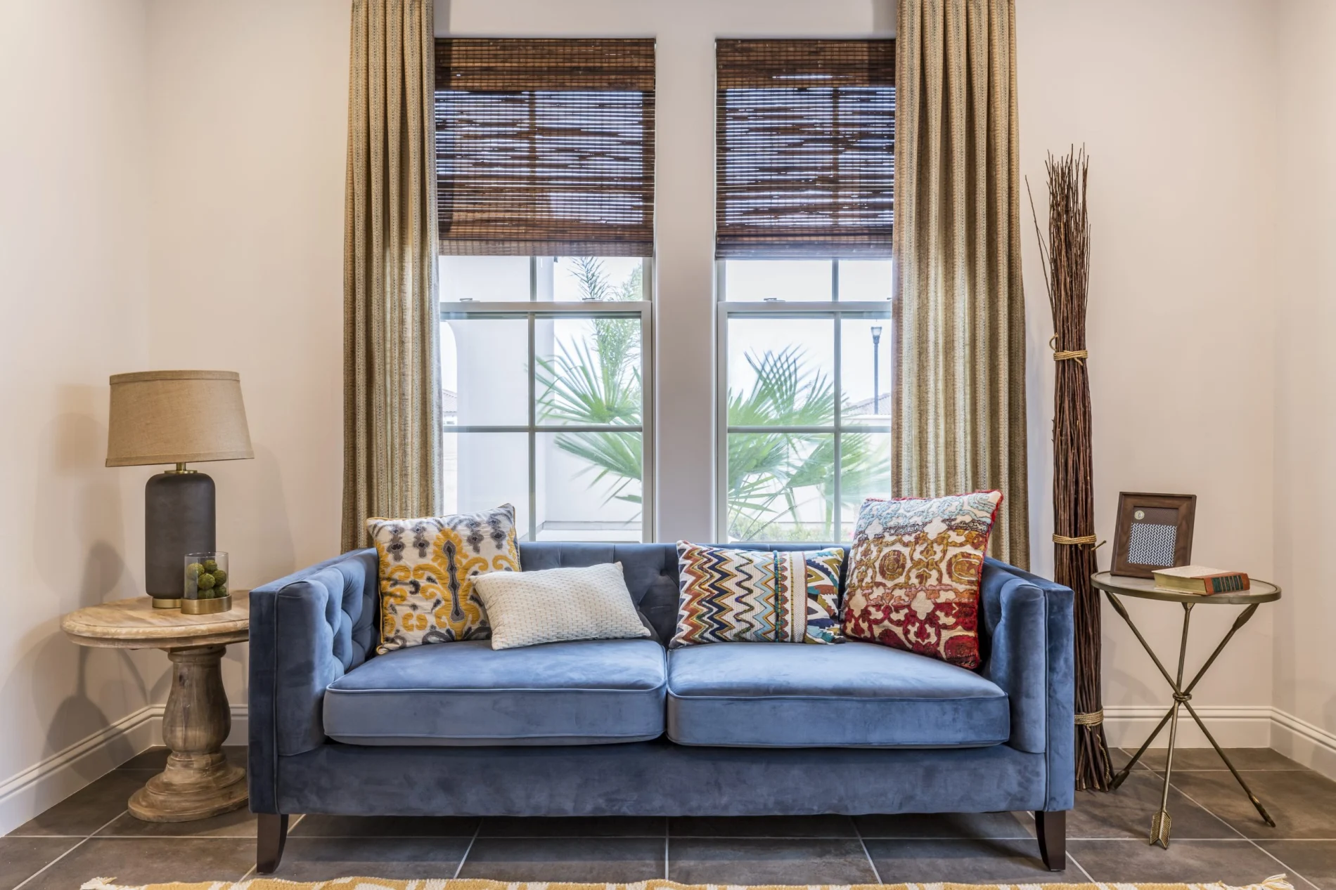 A blue couch with throw pillows seated in front of newly installed replacement windows.