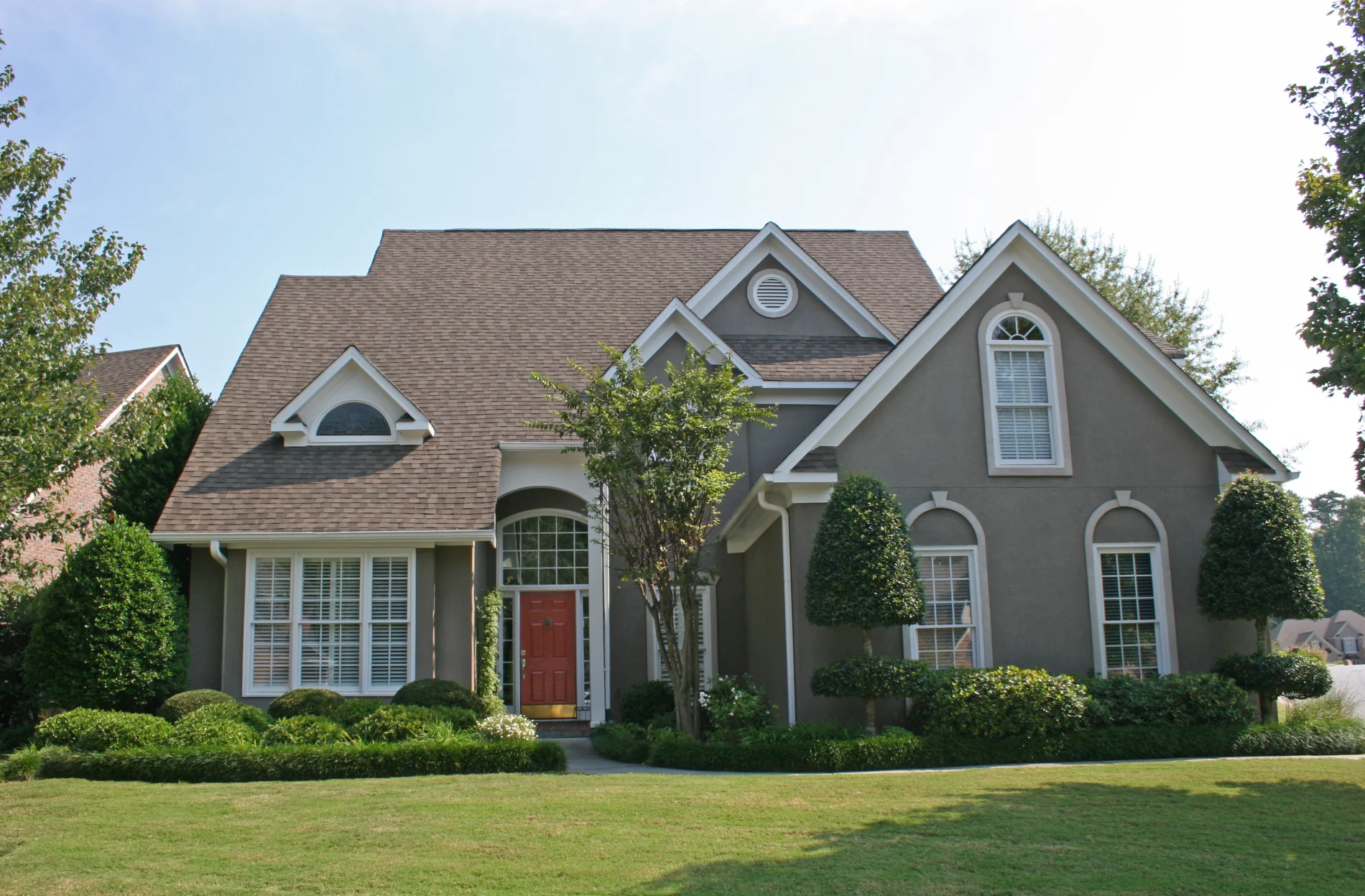 A home with gray stucco and a shingle roof.