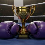Purple gloves rest on the mat of a boxing ring with the championship trophy between them.