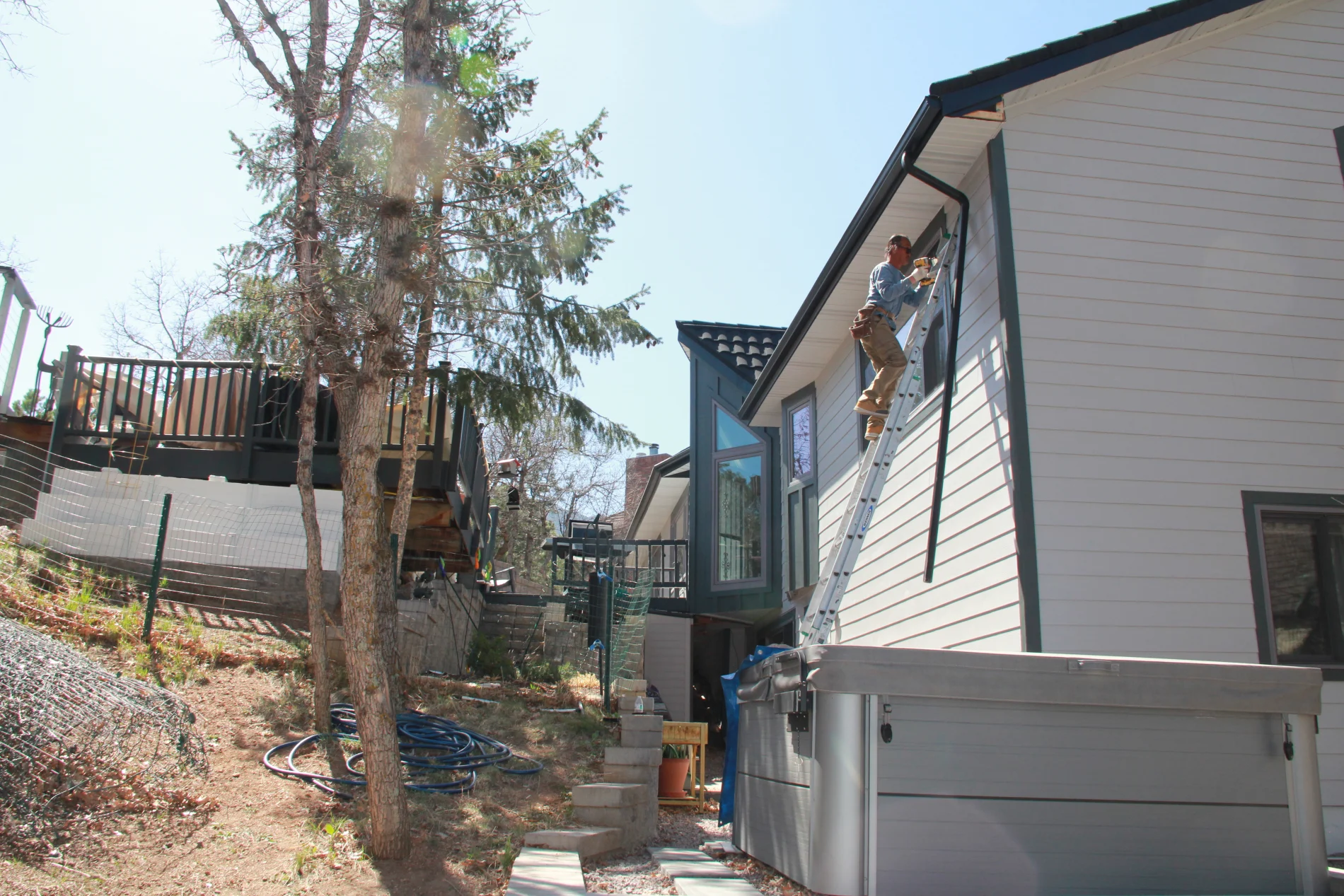 A Peakview contractor on a ladder during a siding installation.