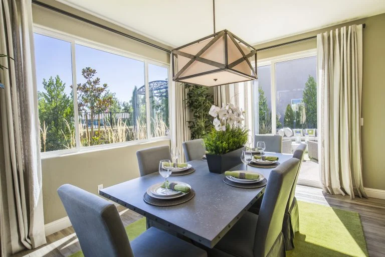 Expert Window Installation | Monument, CO | Peakview Windows, Siding, Stucco A professional window installation featuring large, white-framed picture windows and a sliding glass door allows natural light to fill a modern dining area while offering a scenic view of the surrounding greenery.