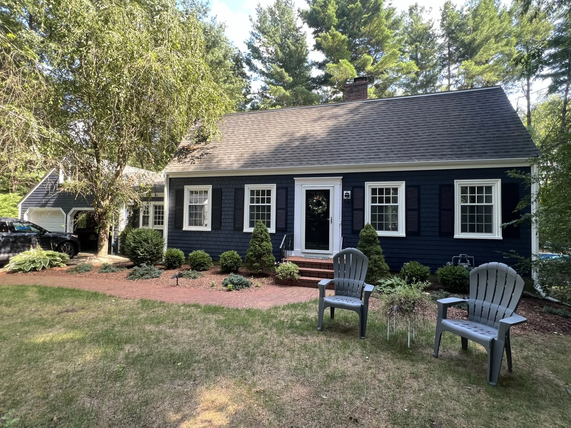 Best Siding Contractor Services | Woodmoor, CO | Peakview Windows, Siding, Stucco A charming residential home features deep blue shake siding paired with classic black shutters and white trim, showcasing exceptional curb appeal achieved through professional siding contractor services.