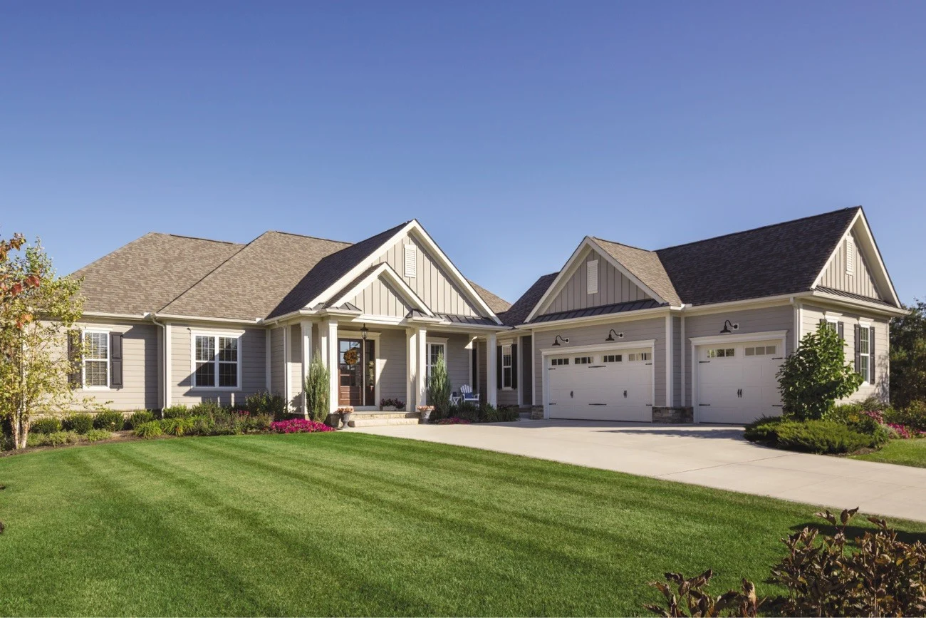 Dependable Siding Contractor Services | Woodmoor, CO | Peakview Windows, Siding, Stucco An expansive single-family home features light gray horizontal lap siding combined with vertical board and batten gables, displaying a beautifully cohesive exterior updated by professional siding contractor services.