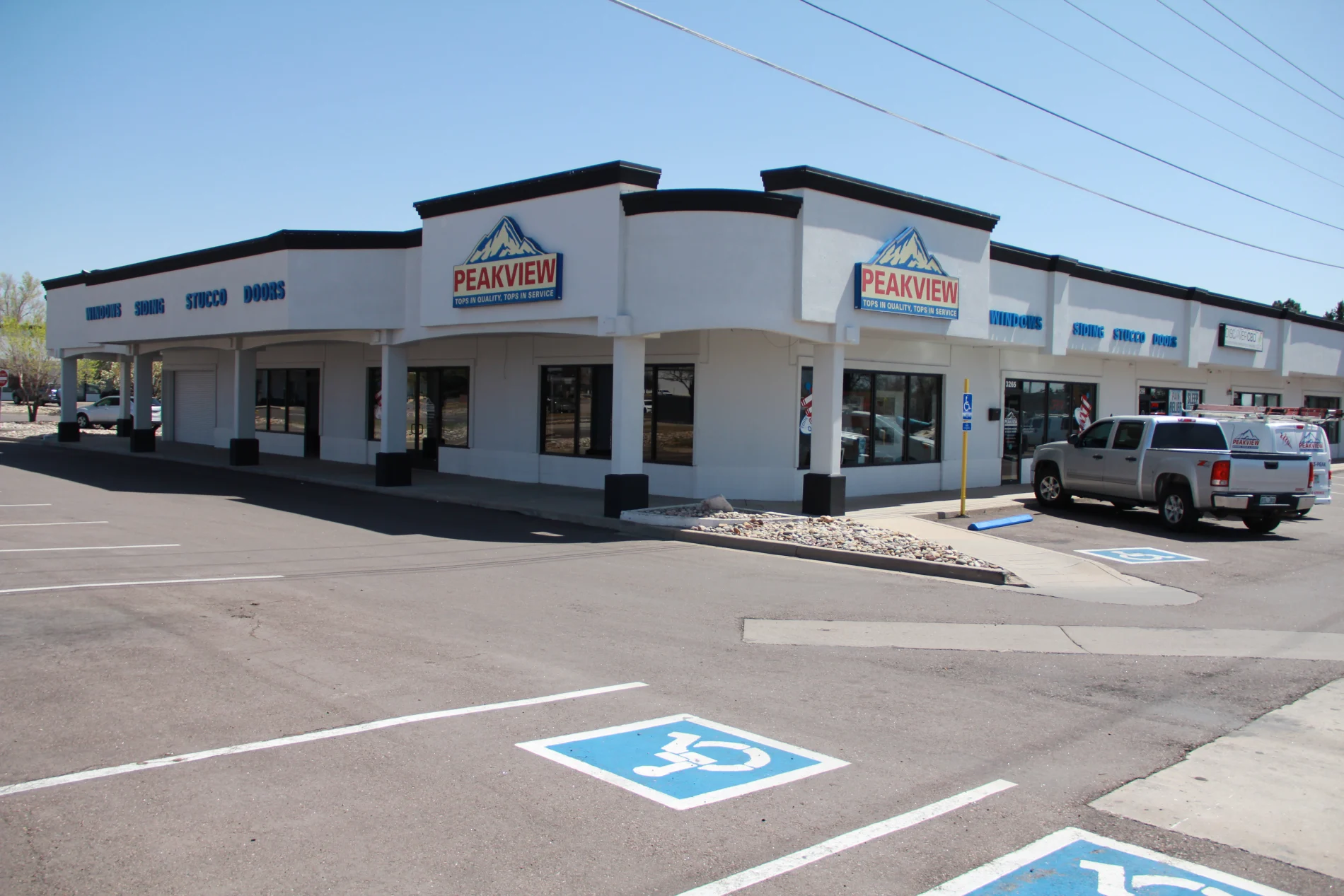 Premier Window Installers | Woodland Park, CO | Peakview Windows, Siding, Stucco A silver pickup truck parked outside the commercial storefront of Peakview Windows, Siding, Stucco & Doors highlights the physical location of these professional window installers in Woodland Park, Colorado.