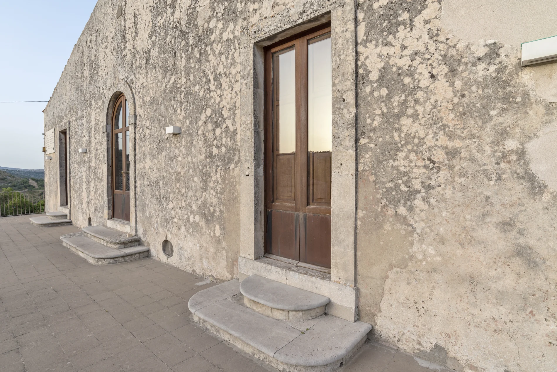 Aging Resistant Stucco Repair Colorado Springs Co Peakview Windows Siding Stucco Aging stucco with stains on the side of a house with wooden doors and glass inserts along the side.