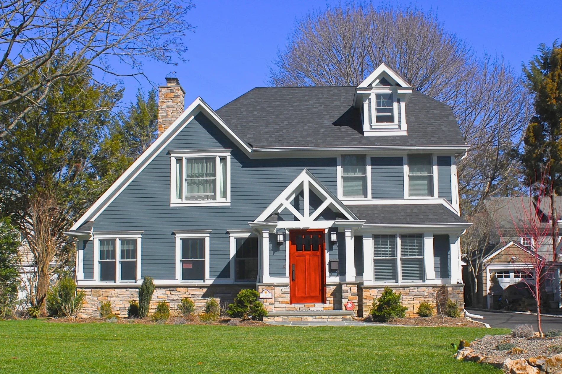 Brilliant Home Improvement Contractor | Old North End, CO | Peakview Windows, Siding, Stucco This beautifully renovated blue two-story house with a vibrant red front door highlights the skilled craftsmanship of a professional home improvement contractor.