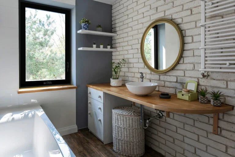 Charming Window Replacements | Old North End, CO | Peakview Windows, Siding, Stucco A modern black-framed window brings natural light into this stylish bathroom, demonstrating the aesthetic appeal of a recent window replacement.
