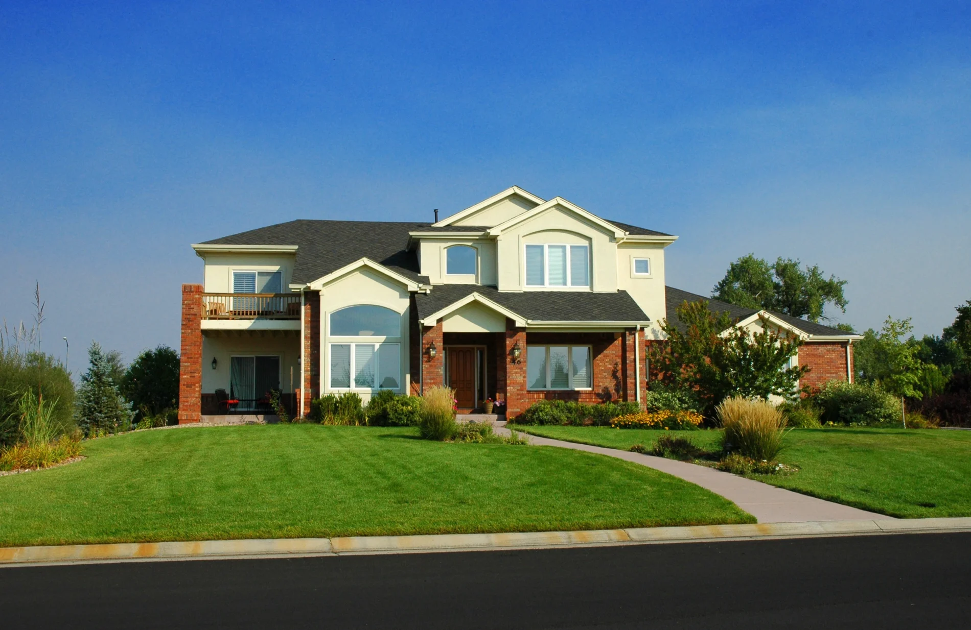 Exceptional Home Improvement Contractor | Palmer Park, CO | Peakview Windows, Siding, Stucco A multi-story home featuring cream-colored upper cladding and classic red brick framing showcases expert work from recent siding replacements.